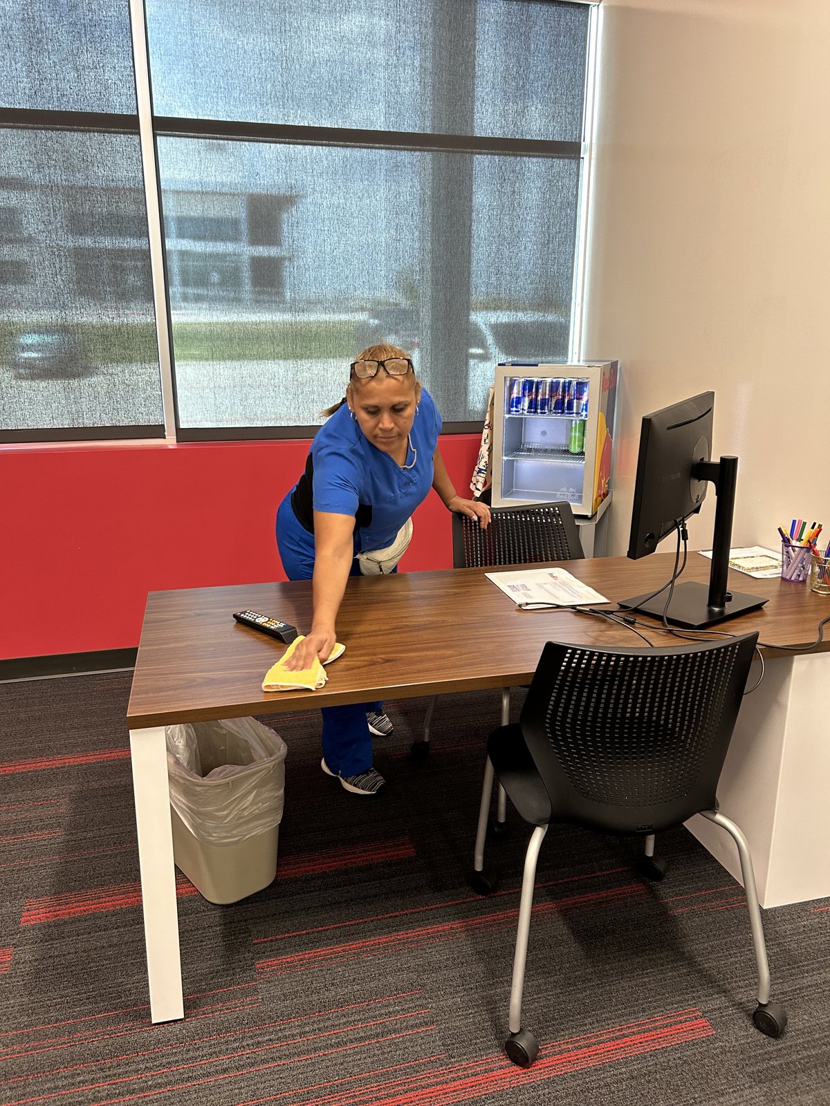 Tamez Cleaning team member wiping down an office desk