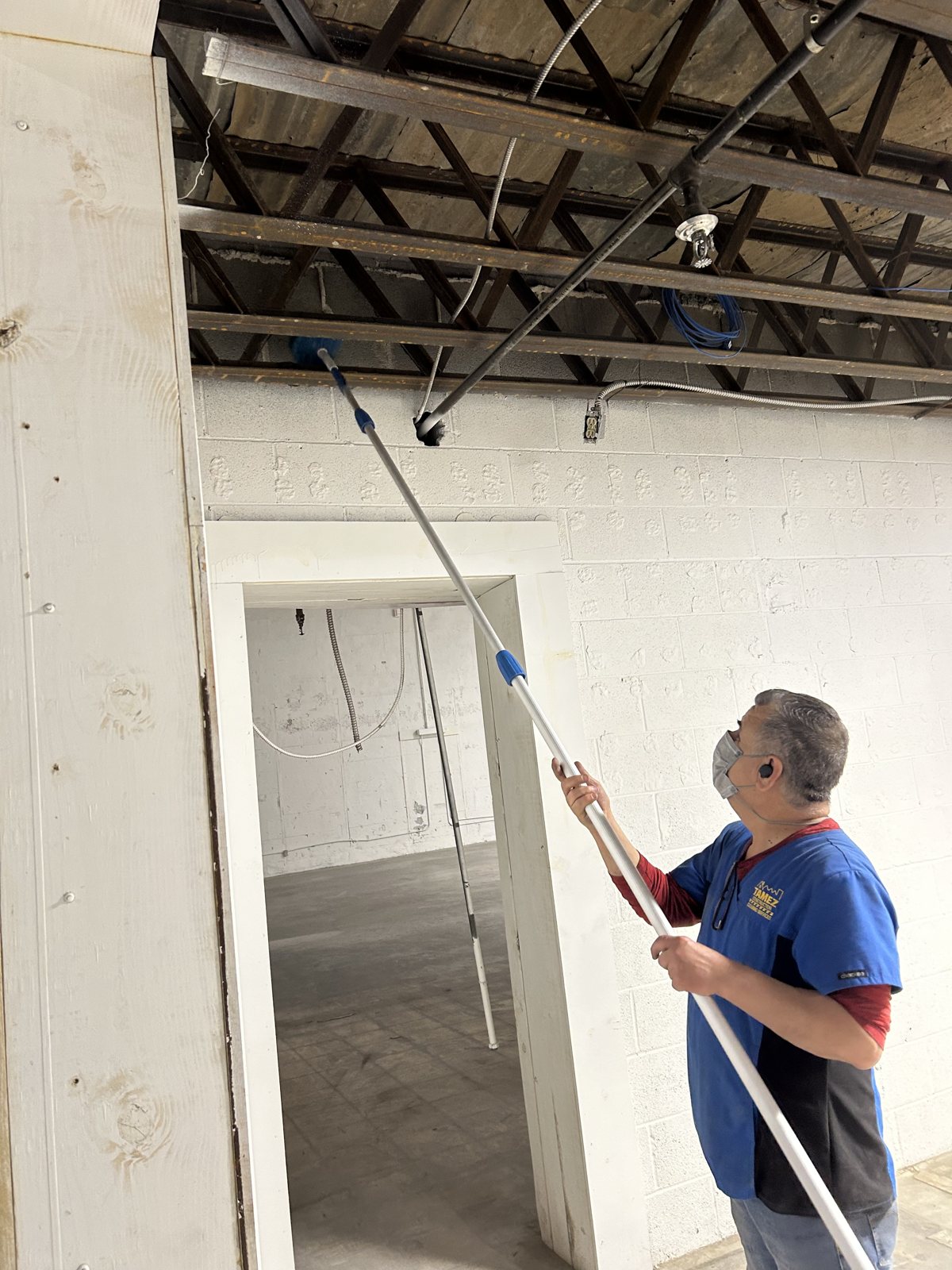 Tamez crew cleaning ceiling and rafters on a post-construction job